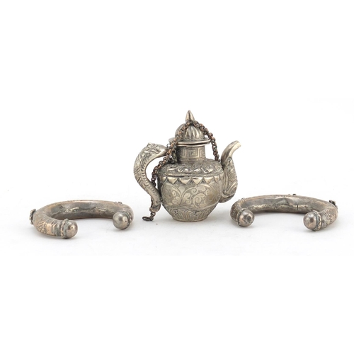 616 - Tibetan Unmarked silver miniature teapot and two silver coloured metal slave bangles, the teapot 7cm... 