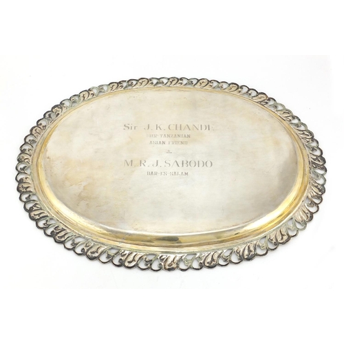 593 - Large oval silver tray with pierced border, presented to Sir J K Chande, 46.5cm in length