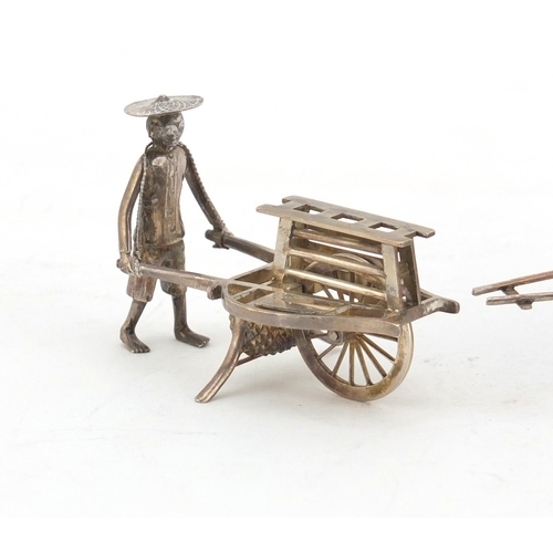 630 - Chinese silver model of a figure pushing a cart and a filigree metal carriage, the largest 11cm in l... 
