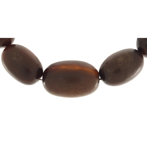 692A - Chinese graduated horn bead necklace, possibly rhinoceros, the largest bead 4.5cm in length, overall... 