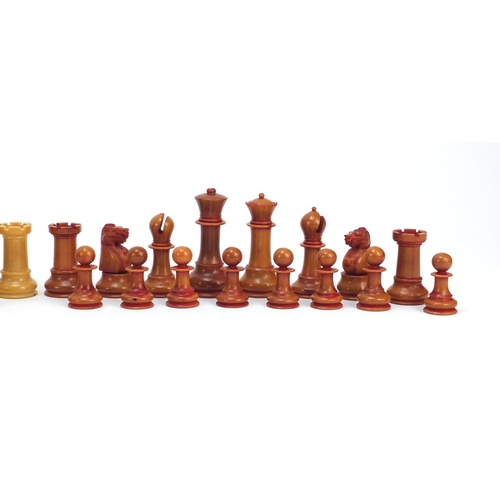 128 - Carved vegetable ivory half stained chess set, the largest piece 9cm high