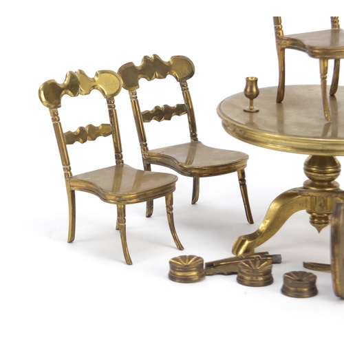 12 - Antique brass dolls house furniture comprising table and six chairs, the table 7.5cm high x 11cm in ... 