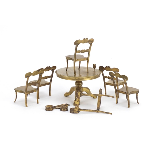 12 - Antique brass dolls house furniture comprising table and six chairs, the table 7.5cm high x 11cm in ... 