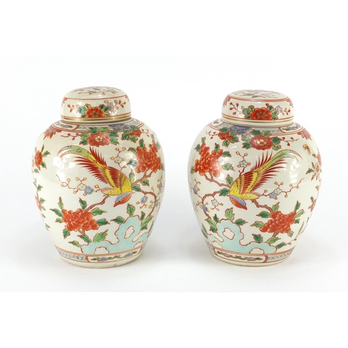 339 - Pair of Chinese porcelain jars with covers, each hand painted with birds of paradise amongst flowers... 