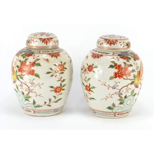 339 - Pair of Chinese porcelain jars with covers, each hand painted with birds of paradise amongst flowers... 