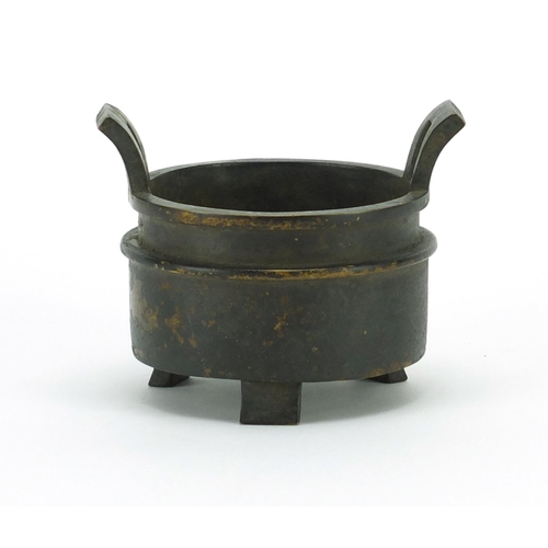 386 - Chinese patinated bronze tripod incense burner with twin handles, character marks to the base, 10cm ... 