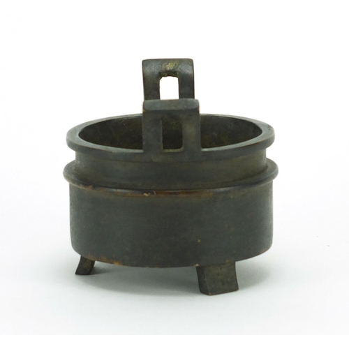 386 - Chinese patinated bronze tripod incense burner with twin handles, character marks to the base, 10cm ... 