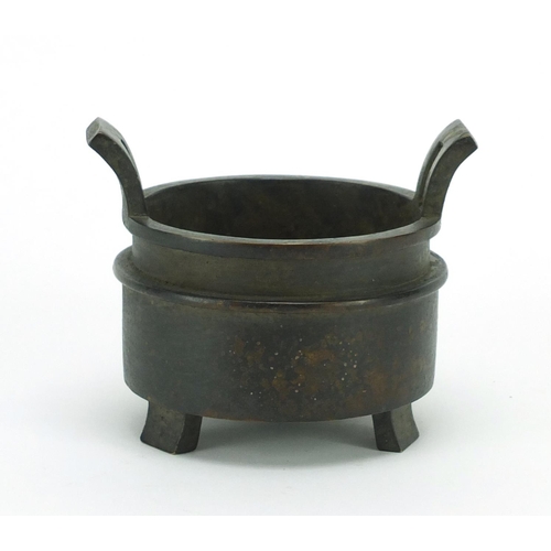 386 - Chinese patinated bronze tripod incense burner with twin handles, character marks to the base, 10cm ... 