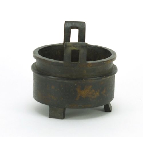 386 - Chinese patinated bronze tripod incense burner with twin handles, character marks to the base, 10cm ... 