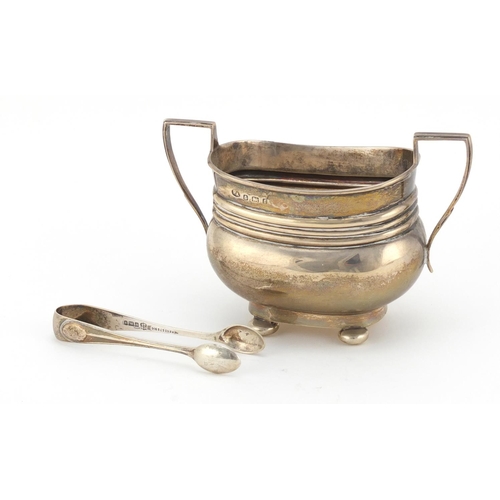 600 - Silver twin handled sugar bowl with ball feet and a pair of silver sugar tongs, Birmingham and Sheff... 