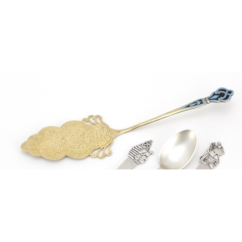 624 - Three Danish silver spoons and a silver gilt cake slice with enamelled handle, the spoons with JG ma... 