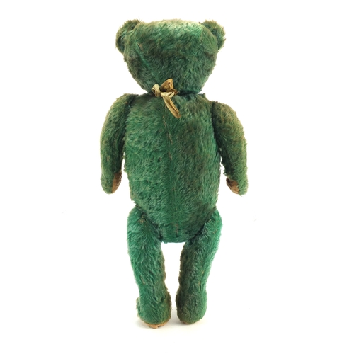 130 - Old green straw filled teddy bear with jointed limbs, 53cm in length