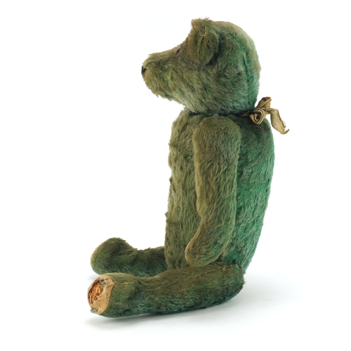 130 - Old green straw filled teddy bear with jointed limbs, 53cm in length