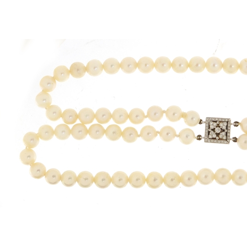 655 - Two string pearl necklace with 18ct white gold diamond clasp, 32cm in length, 62.0g