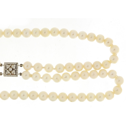 655 - Two string pearl necklace with 18ct white gold diamond clasp, 32cm in length, 62.0g