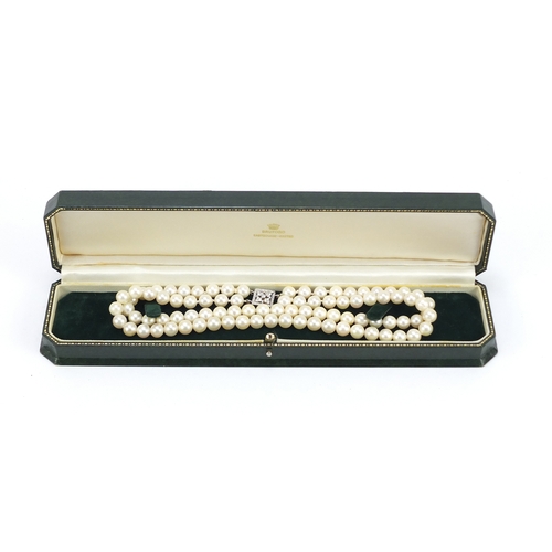 655 - Two string pearl necklace with 18ct white gold diamond clasp, 32cm in length, 62.0g