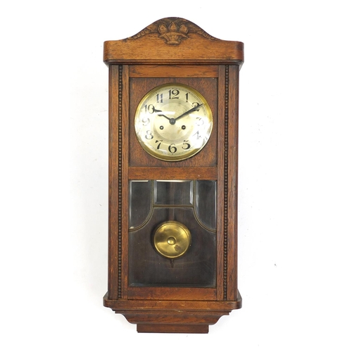 83 - Oak cased wall hanging clock striking on a gong, 80cm high