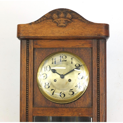 83 - Oak cased wall hanging clock striking on a gong, 80cm high