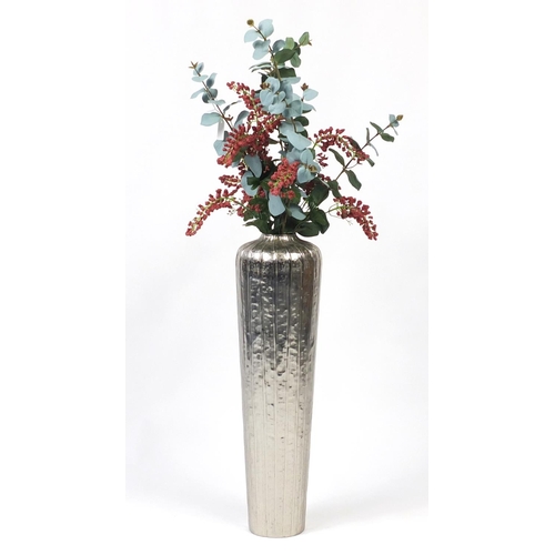 63 - Silvered floorstanding vase with artificial display, 67cm high