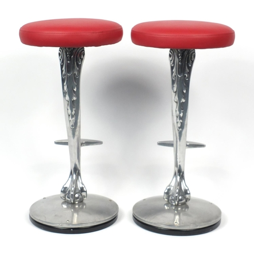 19 - Pair of contemporary polished aluminium bar stools with red leather seats and ball and claw supports... 
