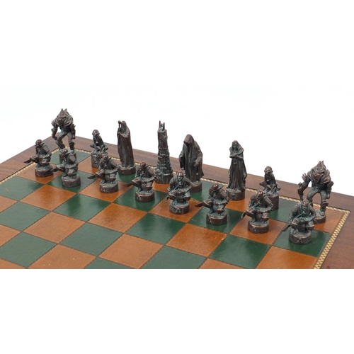 54 - Mahogany chess board with tooled leather insert and a Lord of the Rings chess set