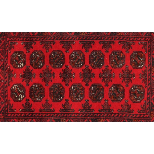 26 - Persian red ground rug with all over geometric design, 120cm x 80cm