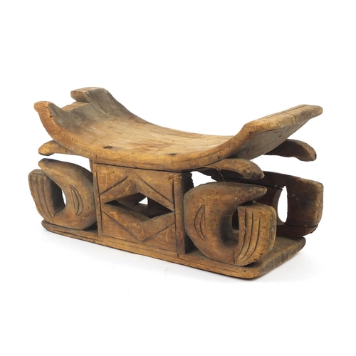 71 - Tribal interest carved wood head rest, 51cm in length