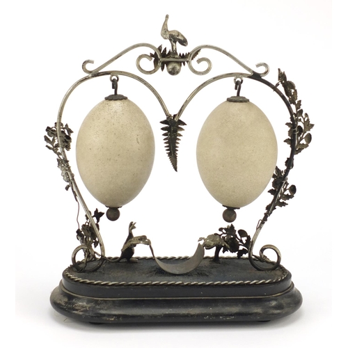 117 - Australian carved emu egg garniture with silvered stand, 35cm high