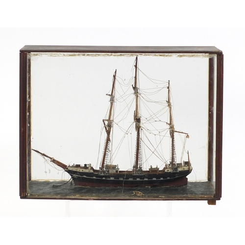 109 - Wooden model of a rigged sailing ship, housed in a mahogany and glass display case, 42cm in length