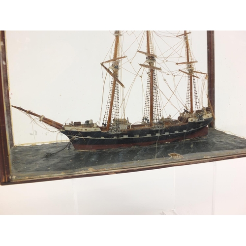 109 - Wooden model of a rigged sailing ship, housed in a mahogany and glass display case, 42cm in length