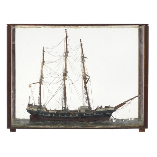 109 - Wooden model of a rigged sailing ship, housed in a mahogany and glass display case, 42cm in length