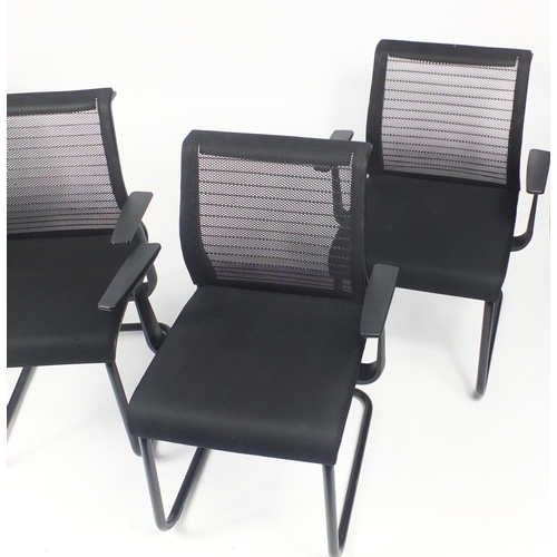 27 - Set of four black reception chairs with mesh backs, 83cm high