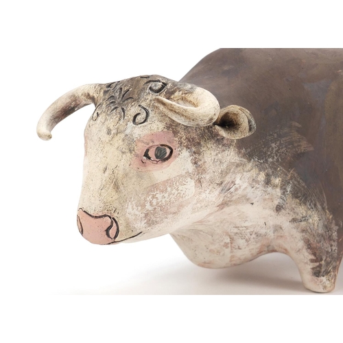 139 - Stylised pottery model of a bull, incised initials and dated '12 to the base, 39cm in length