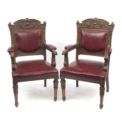 2067 - Pair of carved walnut elbow chairs with red upholstered back, seat and elbow pads, each 107cm high