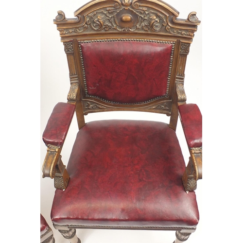 2067 - Pair of carved walnut elbow chairs with red upholstered back, seat and elbow pads, each 107cm high