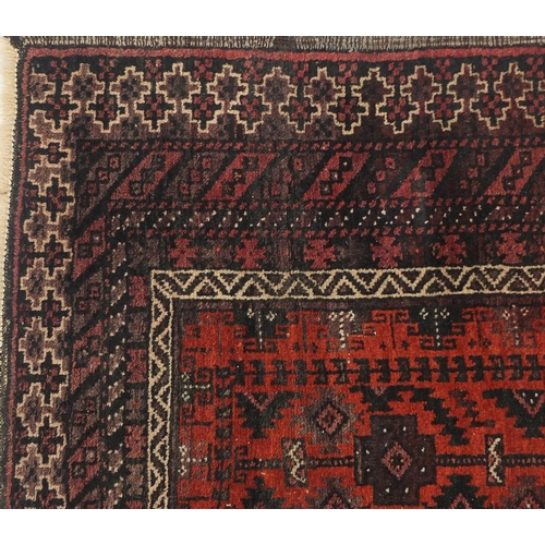 2062 - Persian red ground rug with all over geometric design, 240cm x 118cm