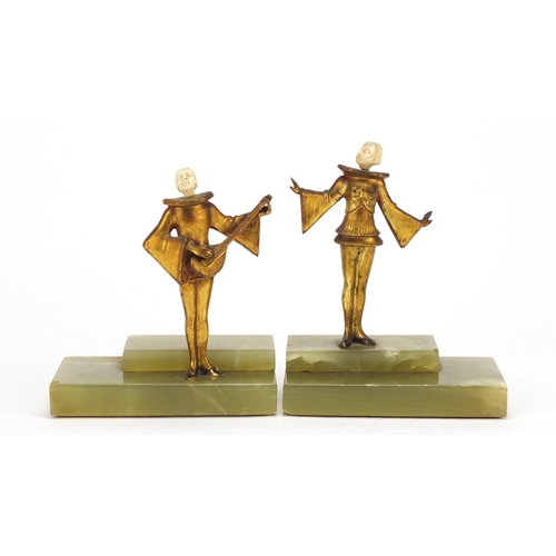 579 - Pair of Art Deco musicians with carved ivory heads, raised on rectangular stepped onyx bases, the la... 