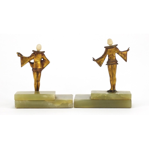 579 - Pair of Art Deco musicians with carved ivory heads, raised on rectangular stepped onyx bases, the la... 