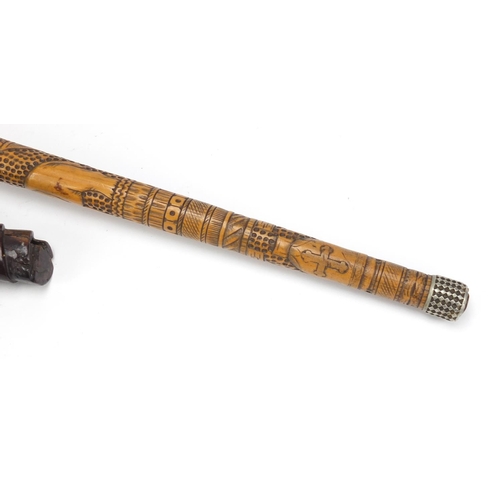 126 - Two carved wood walking stick handles including one carved with a hand clenching a scroll, the large... 