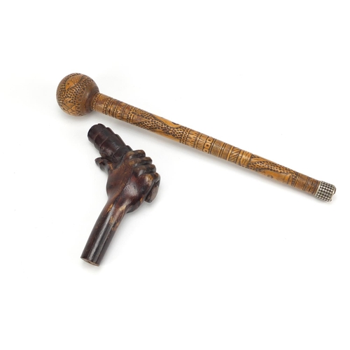 126 - Two carved wood walking stick handles including one carved with a hand clenching a scroll, the large... 