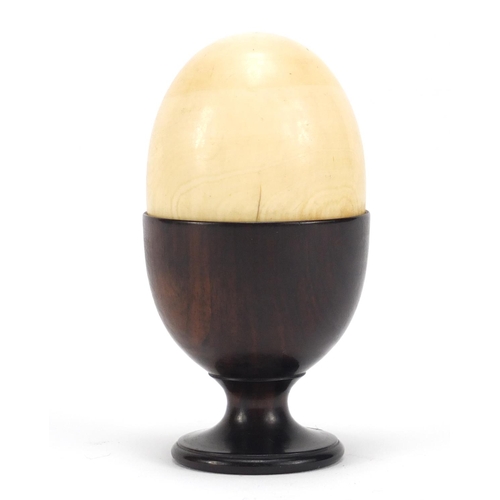 132 - Stained ivory egg cup with an ivory half egg, 9cm high