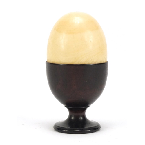 132 - Stained ivory egg cup with an ivory half egg, 9cm high