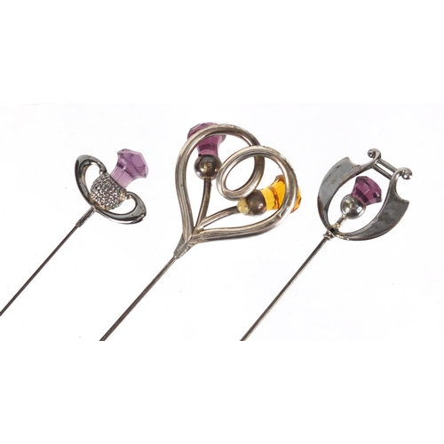 7 - Three Art Nouveau unmarked silver thistle design hat pins set with amethyst and citrine, the largest... 