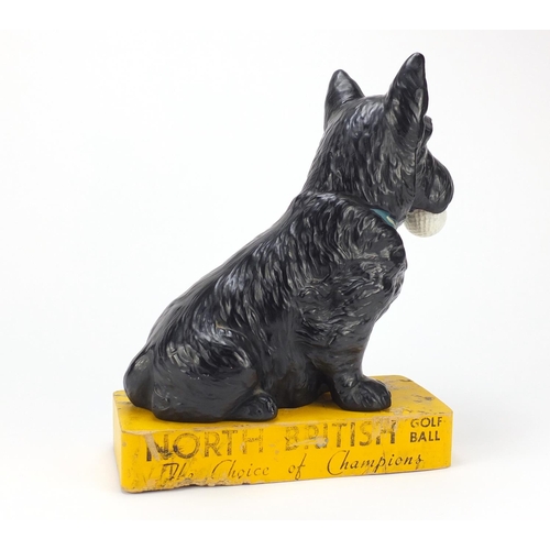 111 - Rare North British Golf ball advertising pottery figure of a Scottie dog holding a golf ball on stan... 