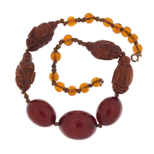 776 - Chinese cherry amber coloured bead and carved coquilla nut necklace, 40cm in length