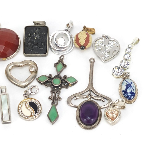 2595 - Mostly silver pendants including a Russian enamelled cross, some set with semi precious stones, 40.8... 