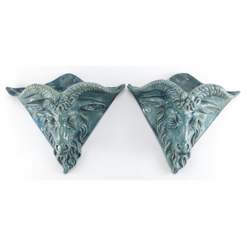 600 - Pair of blue glazed rams head design pottery wall pockets of triangular form, 26cm H x 31cm W