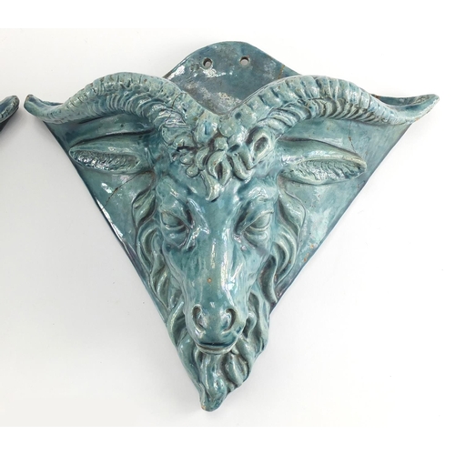 600 - Pair of blue glazed rams head design pottery wall pockets of triangular form, 26cm H x 31cm W