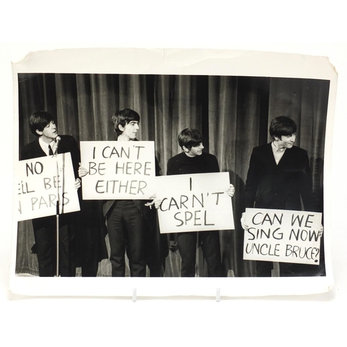 203 - Vintage black and white photograph of the Beatles standing on stage, 30.5cm x 23.5cm