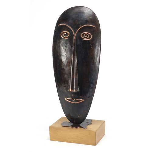 589 - Modernist copper sculpture of a face by Sam Fanaroff raised on a rectangular wood block base, 47cm h... 